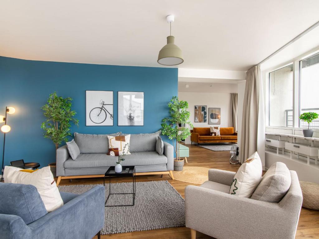 uma sala de estar com dois sofás e uma parede azul em limehome Wolfsburg Porschestraße em Wolfsburg