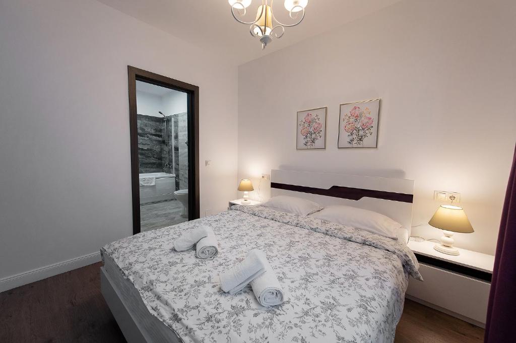 a bedroom with a bed with two towels on it at Tonitza Apartments in Cluj-Napoca