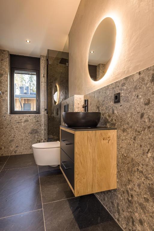 a bathroom with a sink and a tub and a mirror at Perfect Lodgings Panorama in Hart im Zillertal