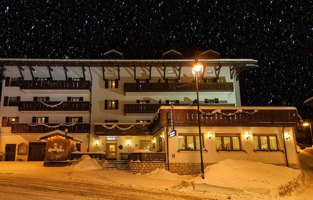 um grande edifício na neve à noite em CASA MIFEL -- APP. GERANIO em Folgaria
