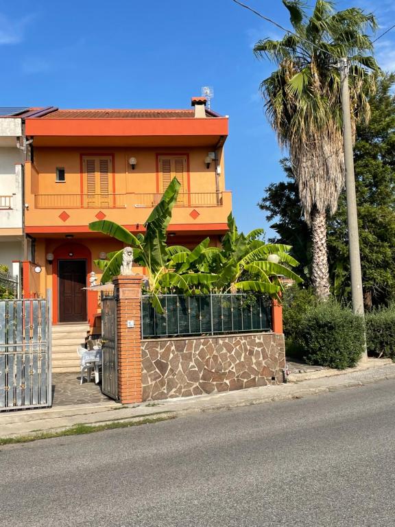 a house with a fence and a palm tree at Residence Don Turi in Villafranca Tirrena