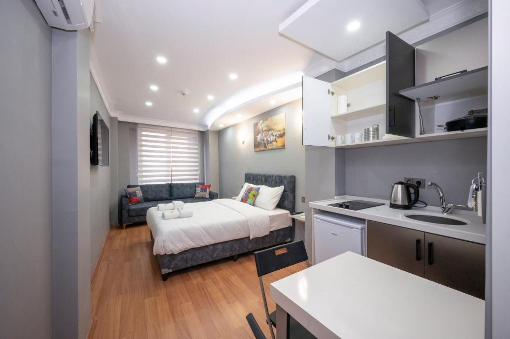 a bedroom with a bed and a kitchen with a sink at Taxim Sunpera Suites in Istanbul