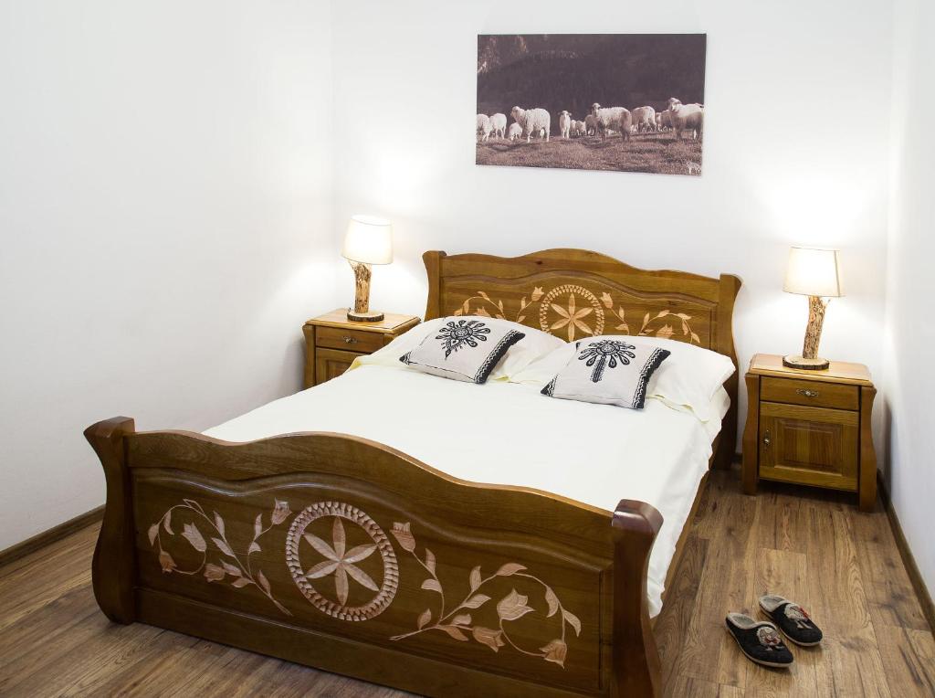 a bedroom with a bed and two night stands with lamps at Między OWCAMI in Sromowce Wyżne