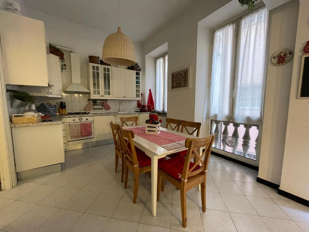 a kitchen with a table and chairs and a kitchen with white cabinets at RAPALLO centro storico a due passi dal mare con ascensore in Rapallo