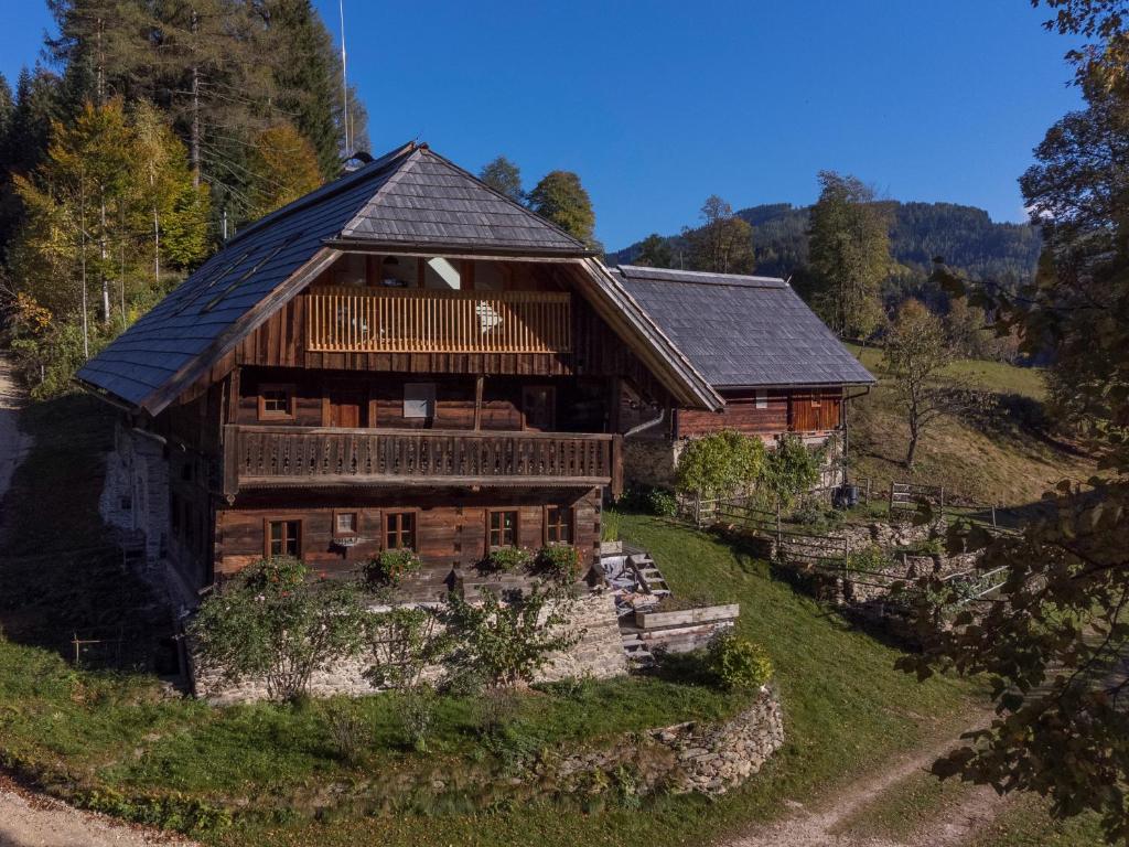 une grande maison en bois sur une colline avec des arbres dans l'établissement Charmante Gästewohnung in altem Bauernhaus in alpiner Alleinlage, à Stanz Im Murztal