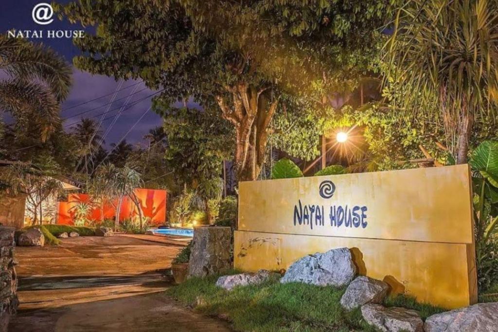 a sign for the main house at night at Natai House in Natai Beach