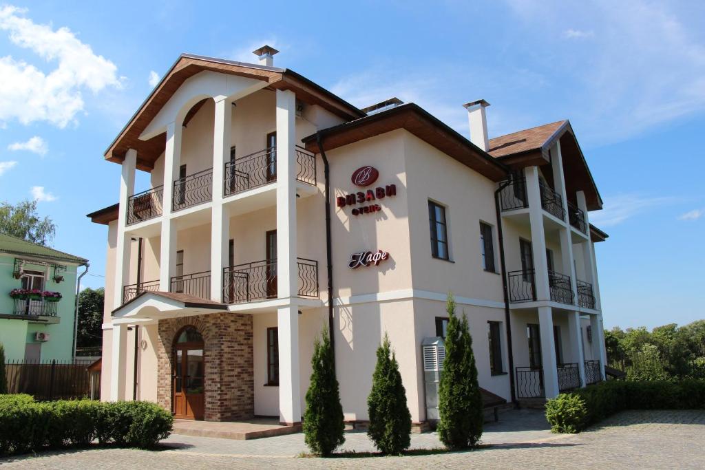 a large white building with a balcony at Vizavi in Staraya Russa