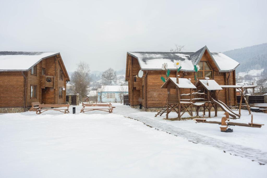 ヴェルホヴィナにあるHotel Gerdan Verkhovinaの雪中の木造建築群