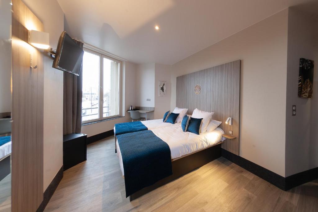 a hotel room with a large bed and a television at Hôtel Nancy Gare-Congrés in Nancy