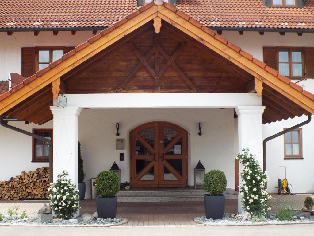 a house with a wooden door with a roof at Hotel Isartaler Hof in Wolfratshausen