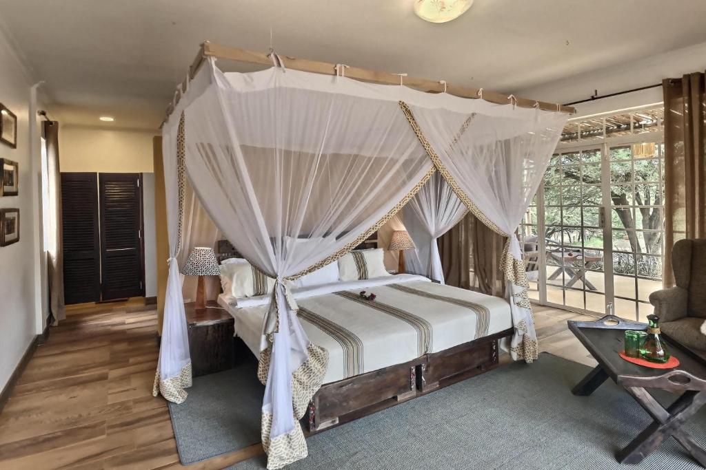 a bedroom with a bed with a canopy at Olerai Lodge in Arusha
