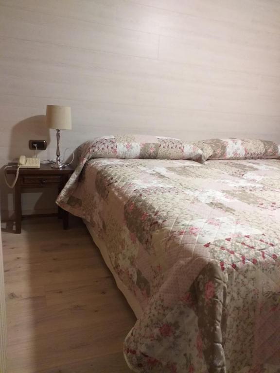 a bedroom with a bed and a table with a lamp at Hotel Giral in Biescas