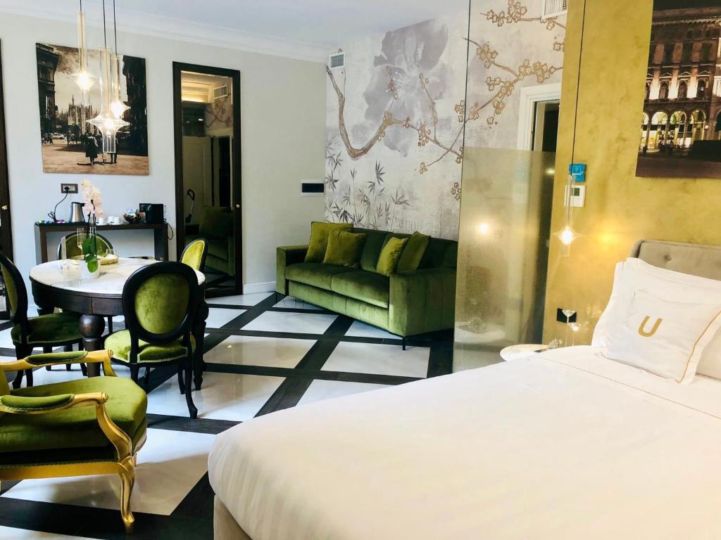 um quarto de hotel com uma cama, um sofá e uma mesa em The Unique em Milão