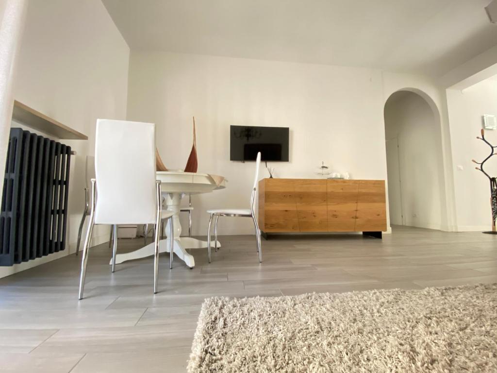 a living room with a table and a tv on a wall at Chez Telly 31 in Verona