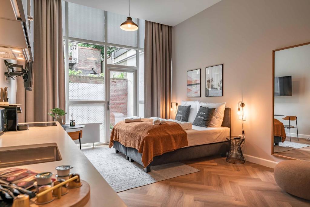 a bedroom with a bed and a large window at limehome Den Haag Keizerstraat in Scheveningen