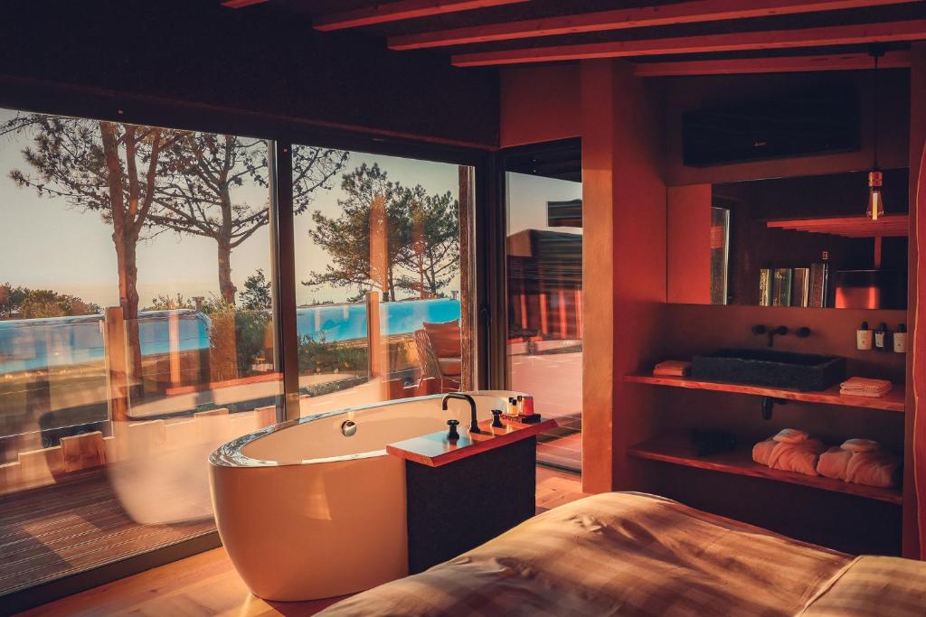 a bathroom with a bath tub and a large window at Charm Nature in Azoia