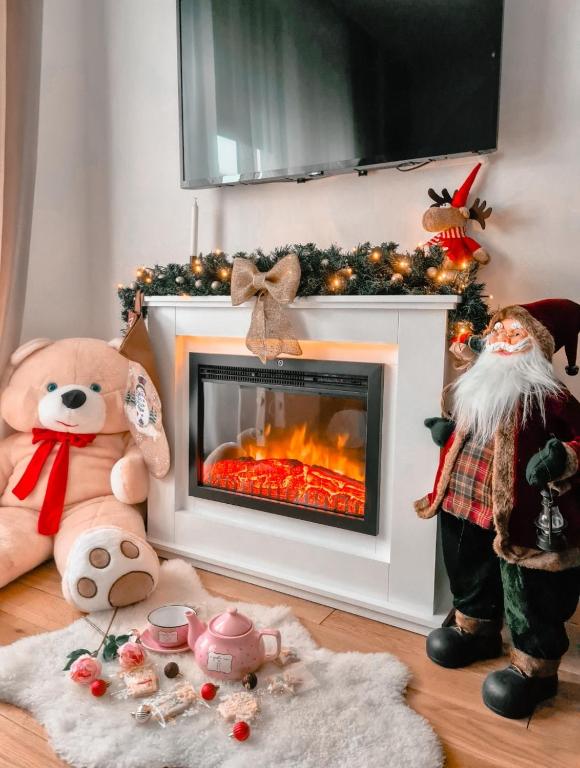 a living room with a fireplace with christmas decorations at Royal apartman Zlatibor in Palisat