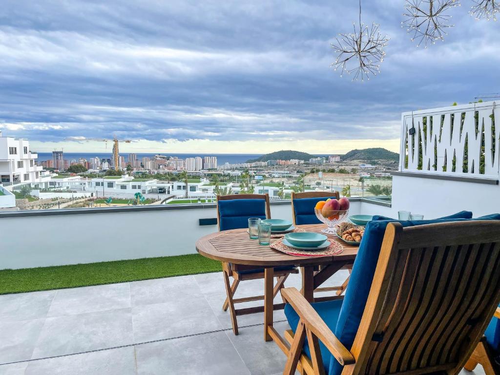 een tafel en stoelen op een balkon met uitzicht bij Apartamento Seascape. Relax, lujo y vistas al mar. in Finestrat
