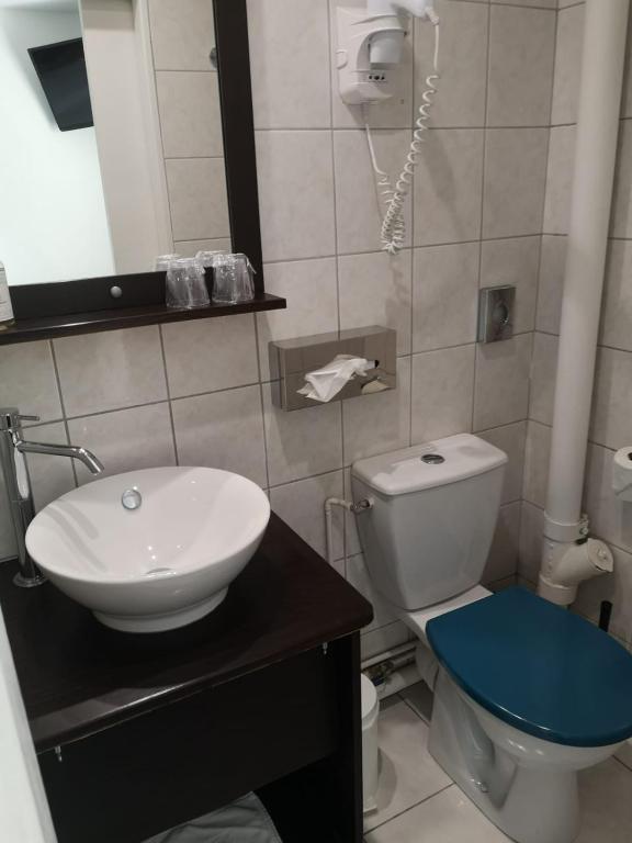 a bathroom with a sink and a toilet and a phone at The Originals Boutique, Hôtel d&#39;Angleterre, Le Havre, centre, plage in Le Havre