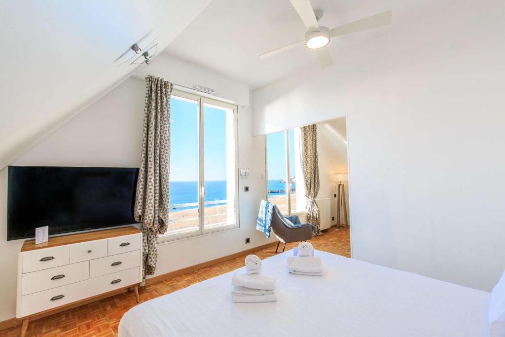 a bedroom with a flat screen tv and a large window at Best Western Hotel De La Plage Saint Marc sur Mer in Saint-Nazaire