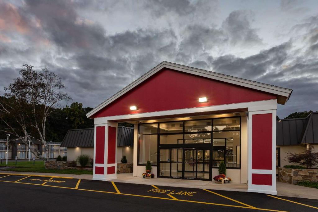 a red and white building on the side of a street at Ramada by Wyndham Windsor Locks in Windsor Locks