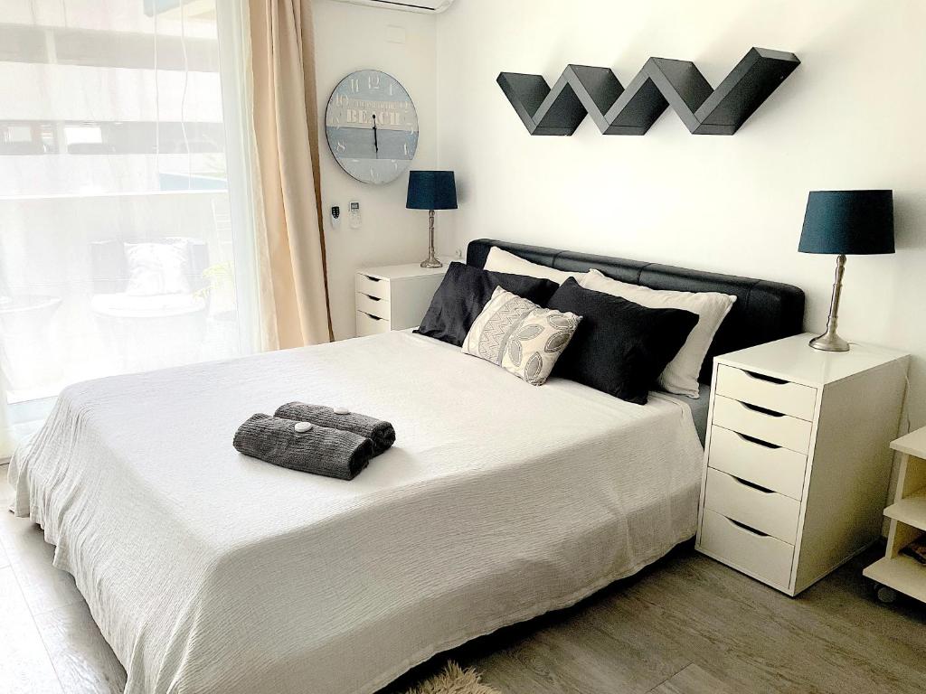 una camera da letto con un grande letto bianco con cuscini neri di Heart of Manly Apartment a Sydney