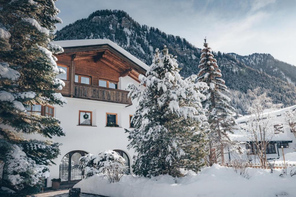 a house in the snow with trees in front of it at Villa Moroder in Ortisei