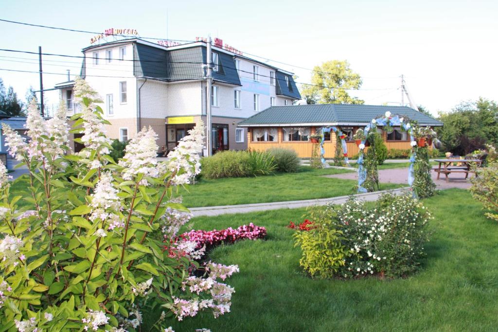 una casa con un jardín con flores en el patio en Postoyaliy Dvor Yam, en Kolpino