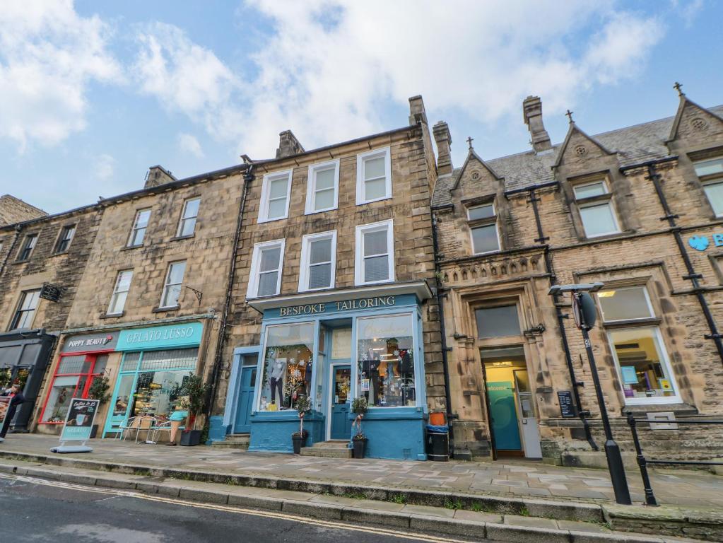 un gran edificio de ladrillo con tiendas en una calle en The Flat, en Barnard Castle