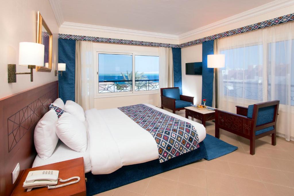 a hotel room with a large bed and a desk at Swiss Wellness Dive Resort in Hurghada