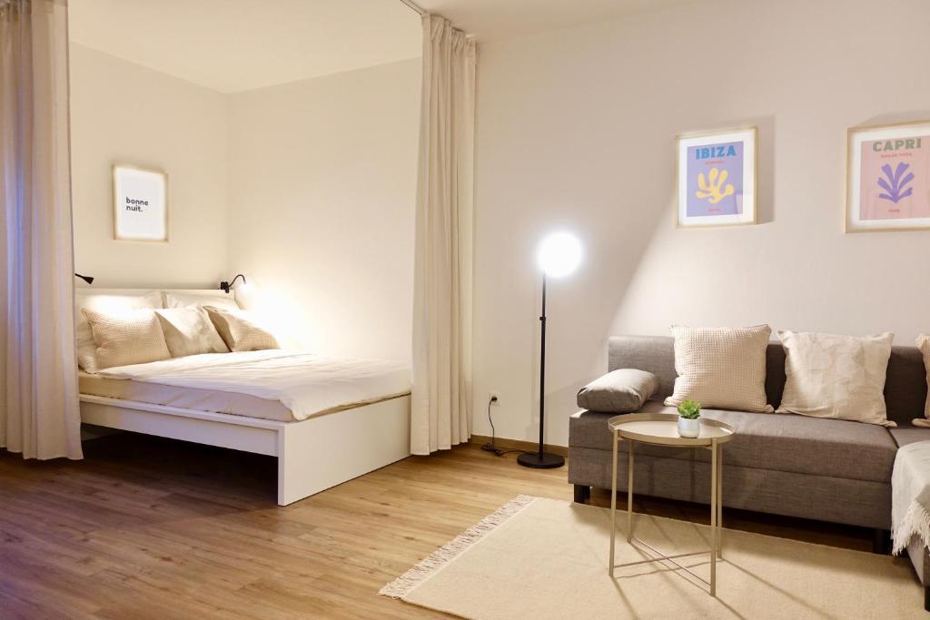 salon z łóżkiem i kanapą w obiekcie Modernes Apartment, Stadtnah, Stellplatz, nähe Mosel w Koblencji