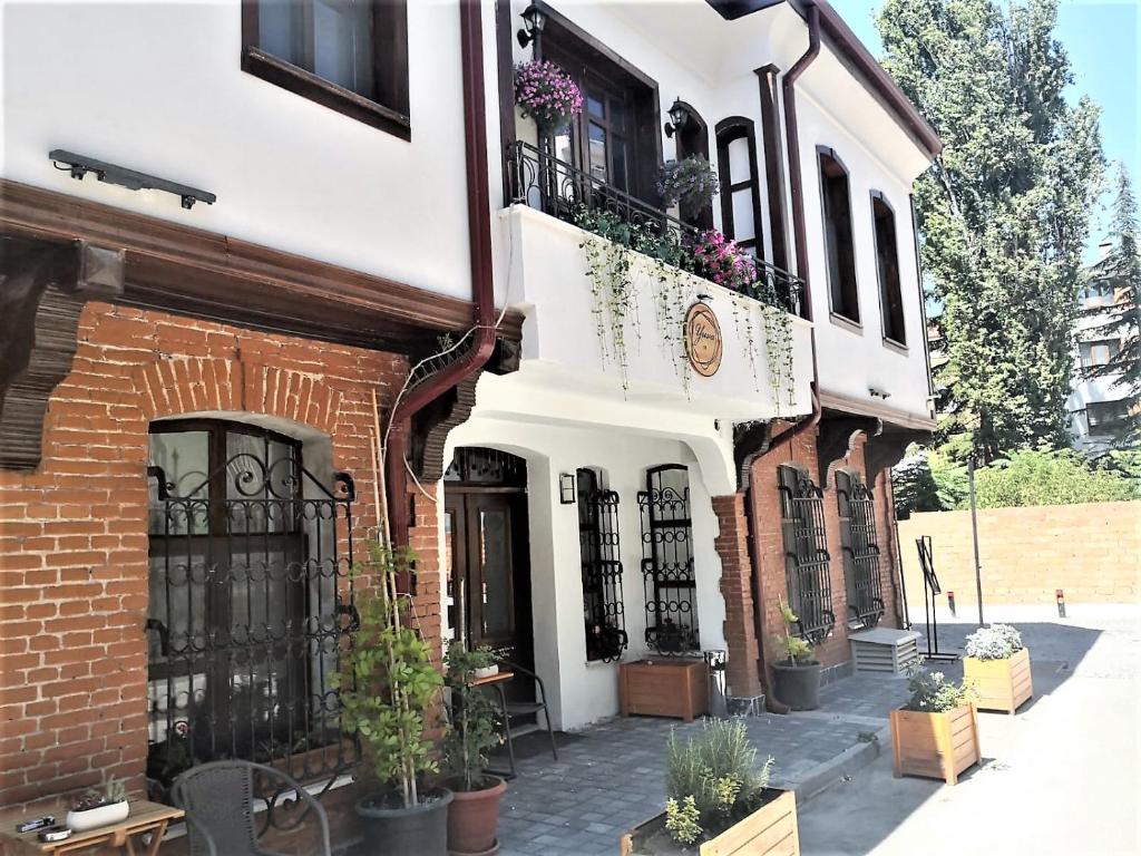 un bâtiment avec des plantes en pot sur son côté dans l'établissement Yuva Butik, à Eskişehir