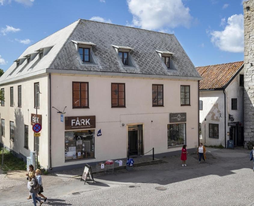 ein großes weißes Gebäude mit Menschen, die davor gehen in der Unterkunft Österport - Visby Lägenhetshotell in Visby