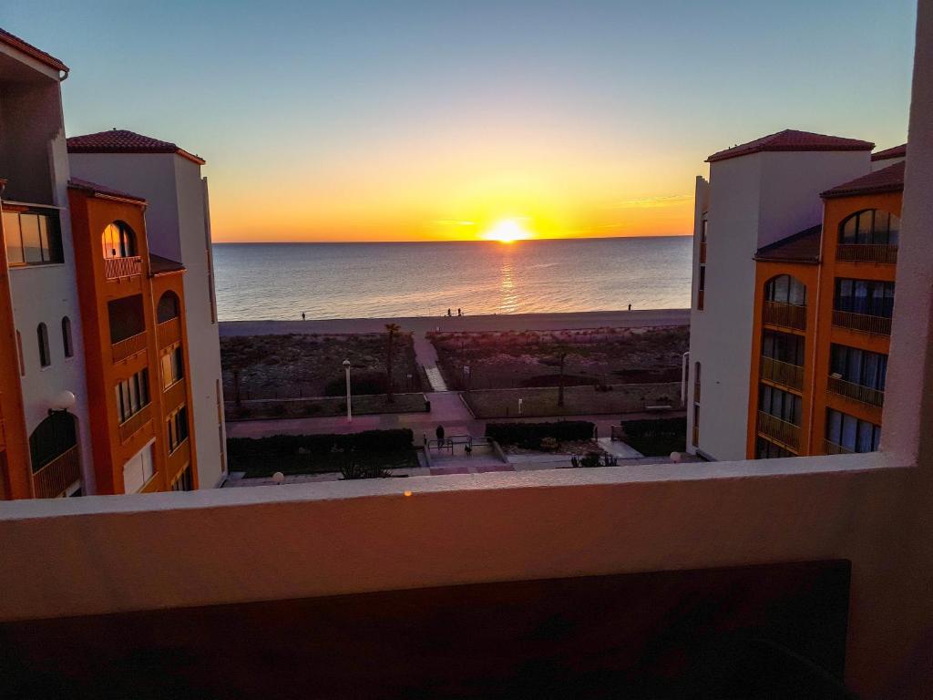 - une vue sur le coucher du soleil depuis le balcon d'un bâtiment dans l'établissement Superbe vue mer avec accès direct plage et parking, au Barcarès