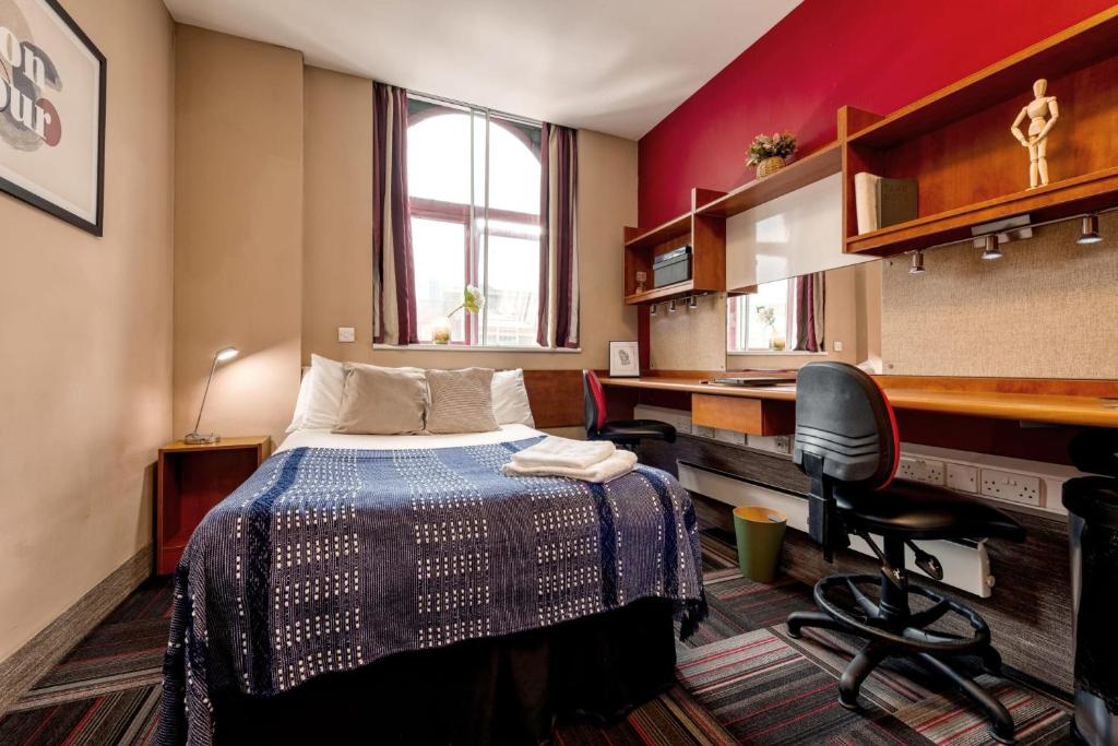 a small room with a bed and a desk and a computer at For Students Only Studio Apartments at Burges House in the heart of Coventry in Coventry