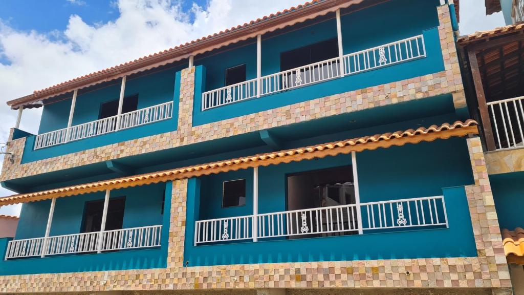 um edifício azul com varandas brancas em Pousada Serra Mística em São Tomé das Letras