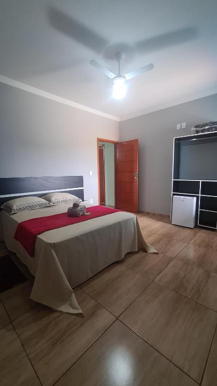 a bedroom with a bed and a flat screen tv at Pousada Serra Mística in São Thomé das Letras