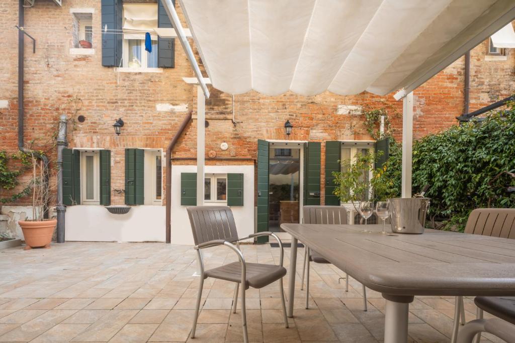 an outdoor patio with a wooden table and chairs at Luxury Garden Mansion R&R in Venice