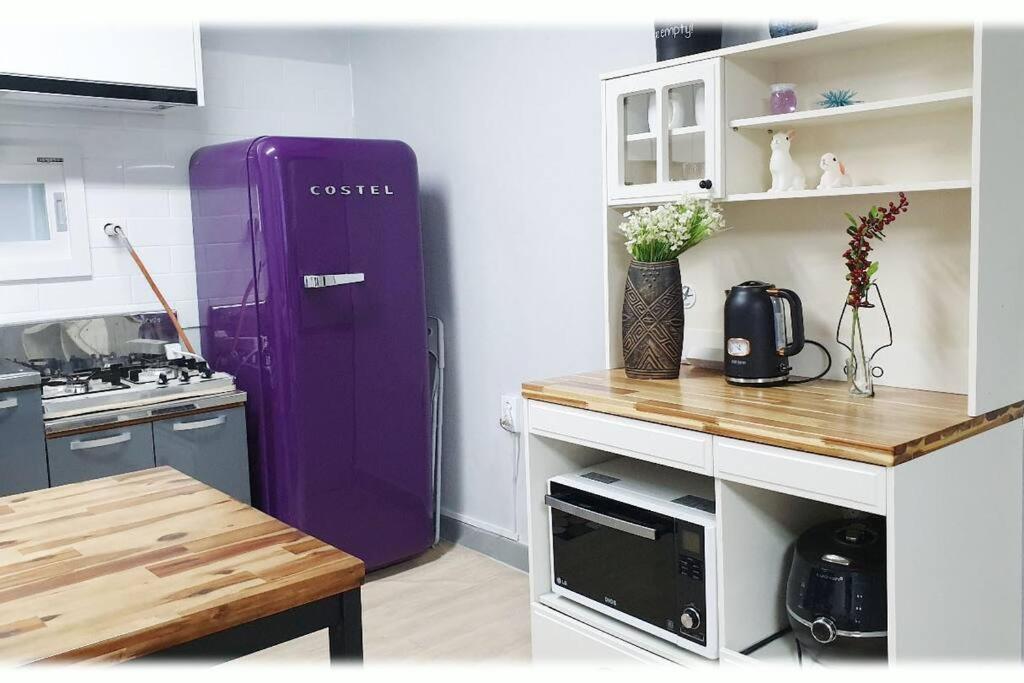 a kitchen with a purple refrigerator in a room at House that only walks on flowery paths in Wonju