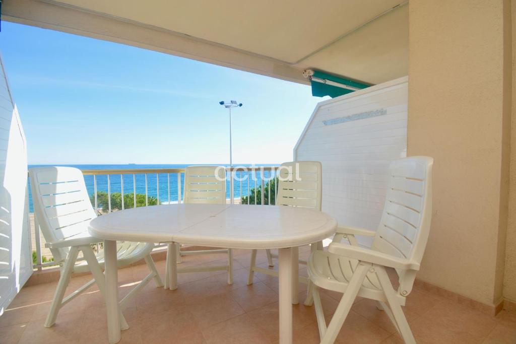 un tavolo bianco e sedie su un balcone con vista sull'oceano di Catalunya C-3 a Platja  d'Aro