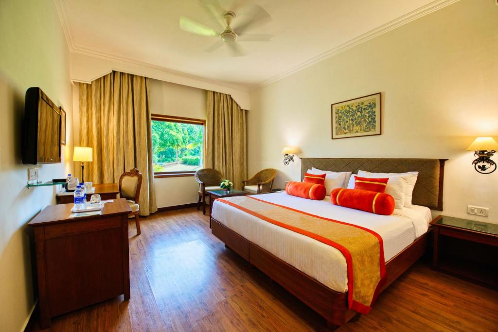 a hotel room with a large bed with red pillows at Clarks Khajuraho in Khajurāho