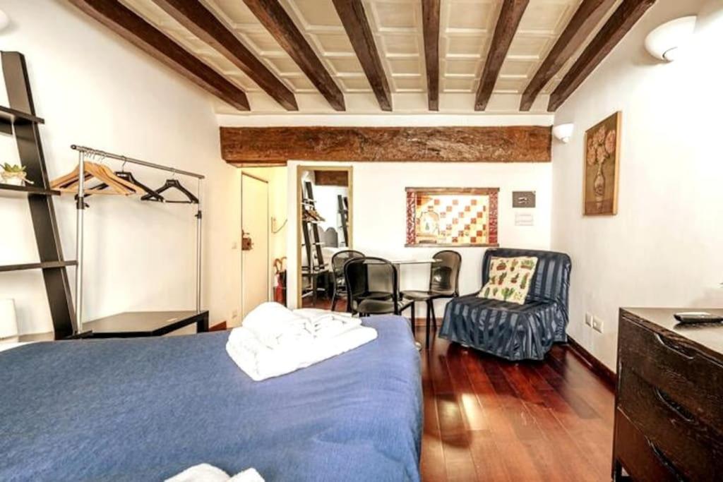 una camera con letto blu e tavolo e sedie di Trastevere Apartments a Roma