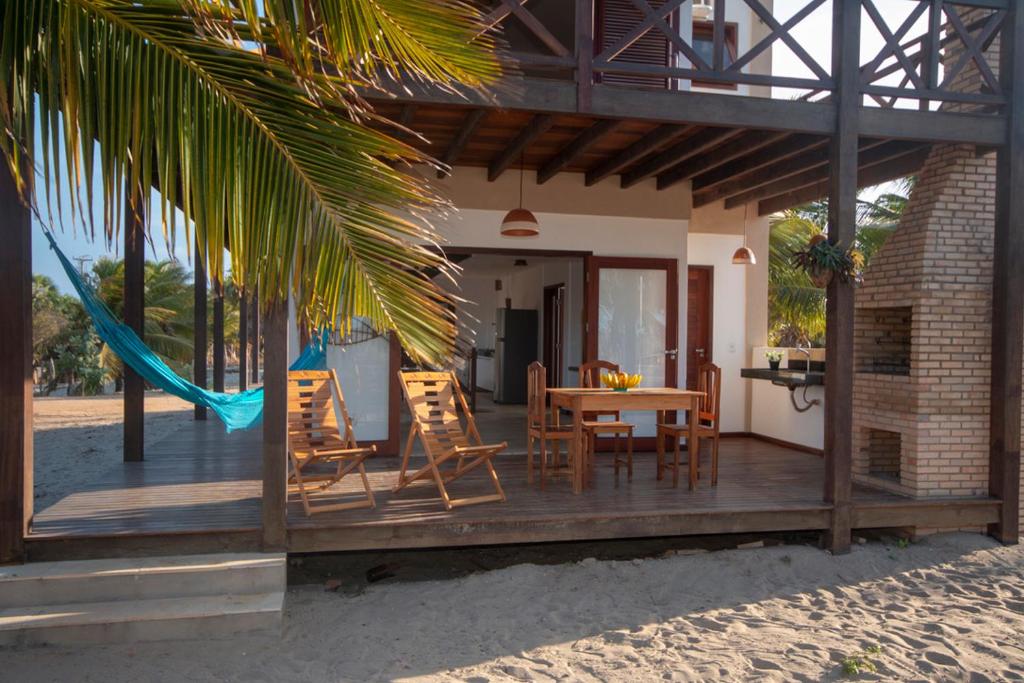 a wooden deck with a table and chairs on the beach at BEACH HOUSE Barra Grande - CASA INTEIRA - WHOLE HOUSE in Barra Grande