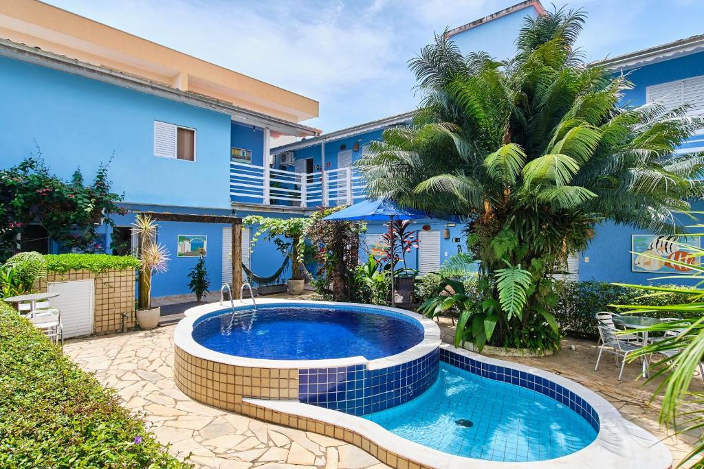 een zwembad voor een blauw huis bij Pousada Remanso do Mar in Ubatuba