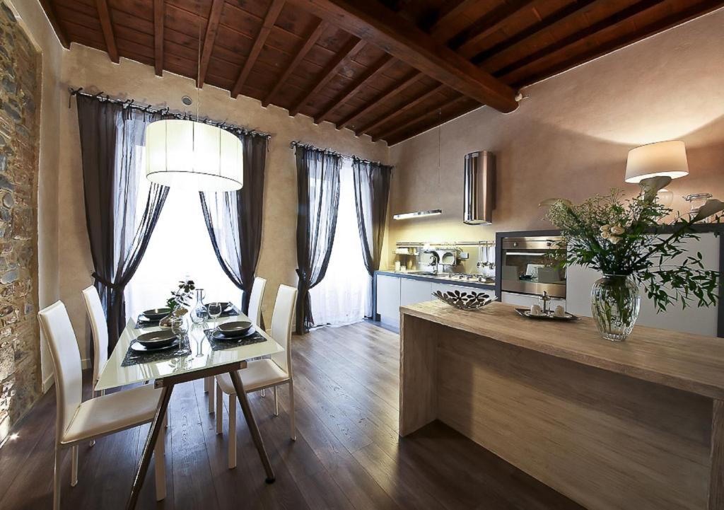 una cucina e una sala da pranzo con tavolo e sedie di Apartments Florence - Giglio santa trinita a Firenze