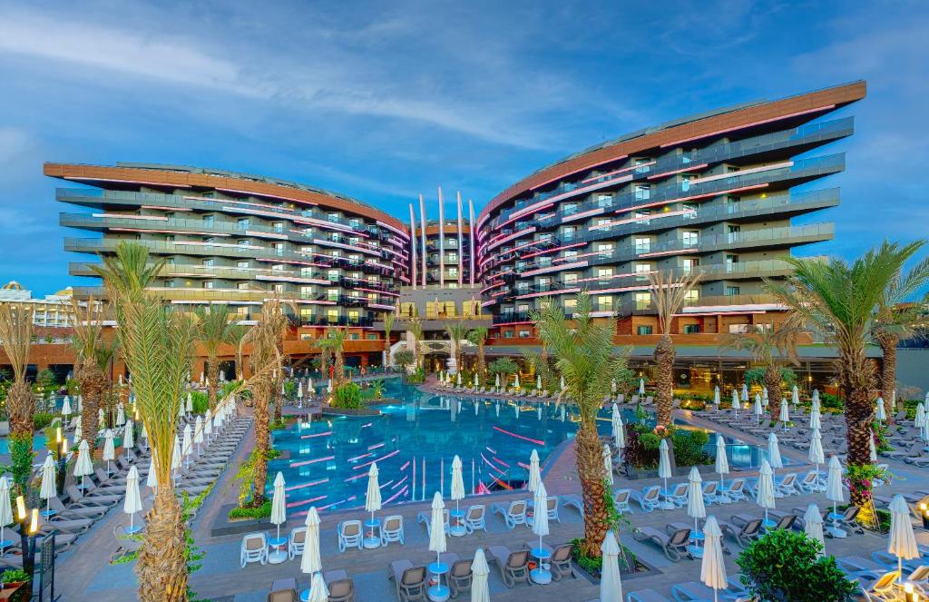 ein Hotel mit einem Pool und Palmen in der Unterkunft Kirman Calyptus Resort & SPA in Side