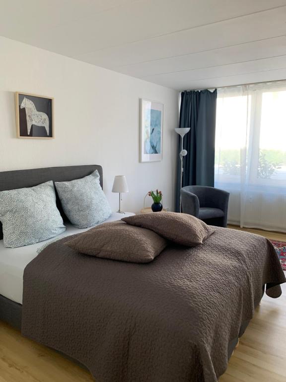 ein Schlafzimmer mit einem großen Bett und einem Stuhl in der Unterkunft Hotel Markgraf in Bad Bellingen