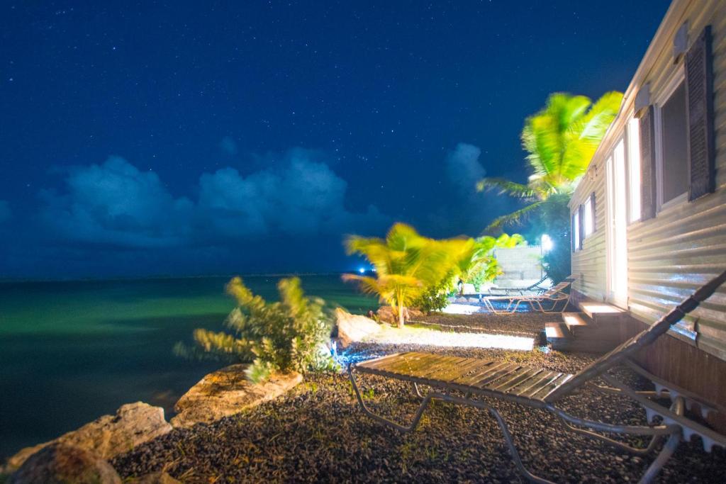 une maison assise sur la plage la nuit dans l'établissement Waterfront 2 Bedroom MobilHome, à Quartier dʼOrléans
