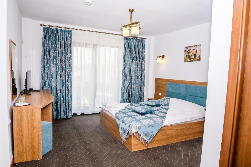 um quarto com uma cama, uma secretária e uma janela em VILA SILFAR em Măcin