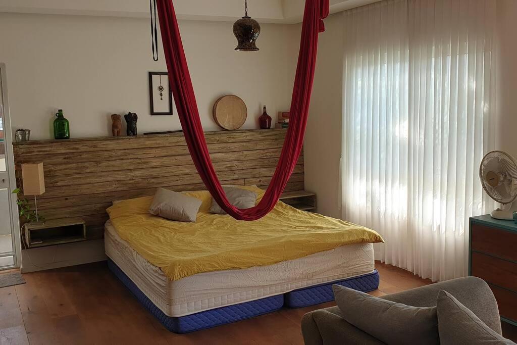 a bedroom with a bed with a hanging canopy at דירת סטודיו מעוצבת עם מרפסת גג גדולה in Rechovot